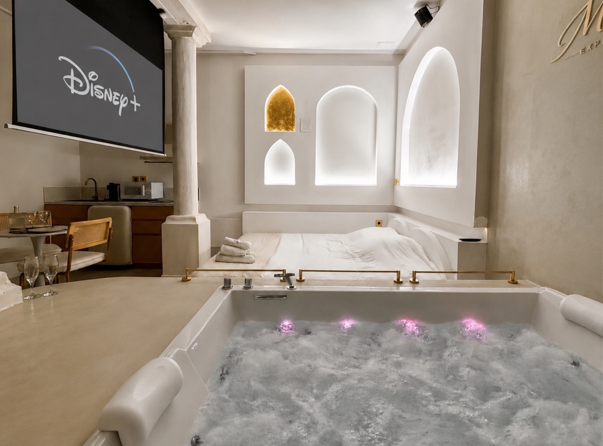 Balnéo Room suite in Tarbes: private jacuzzi, colonnade, white Mykonos-inspired arches and large screen