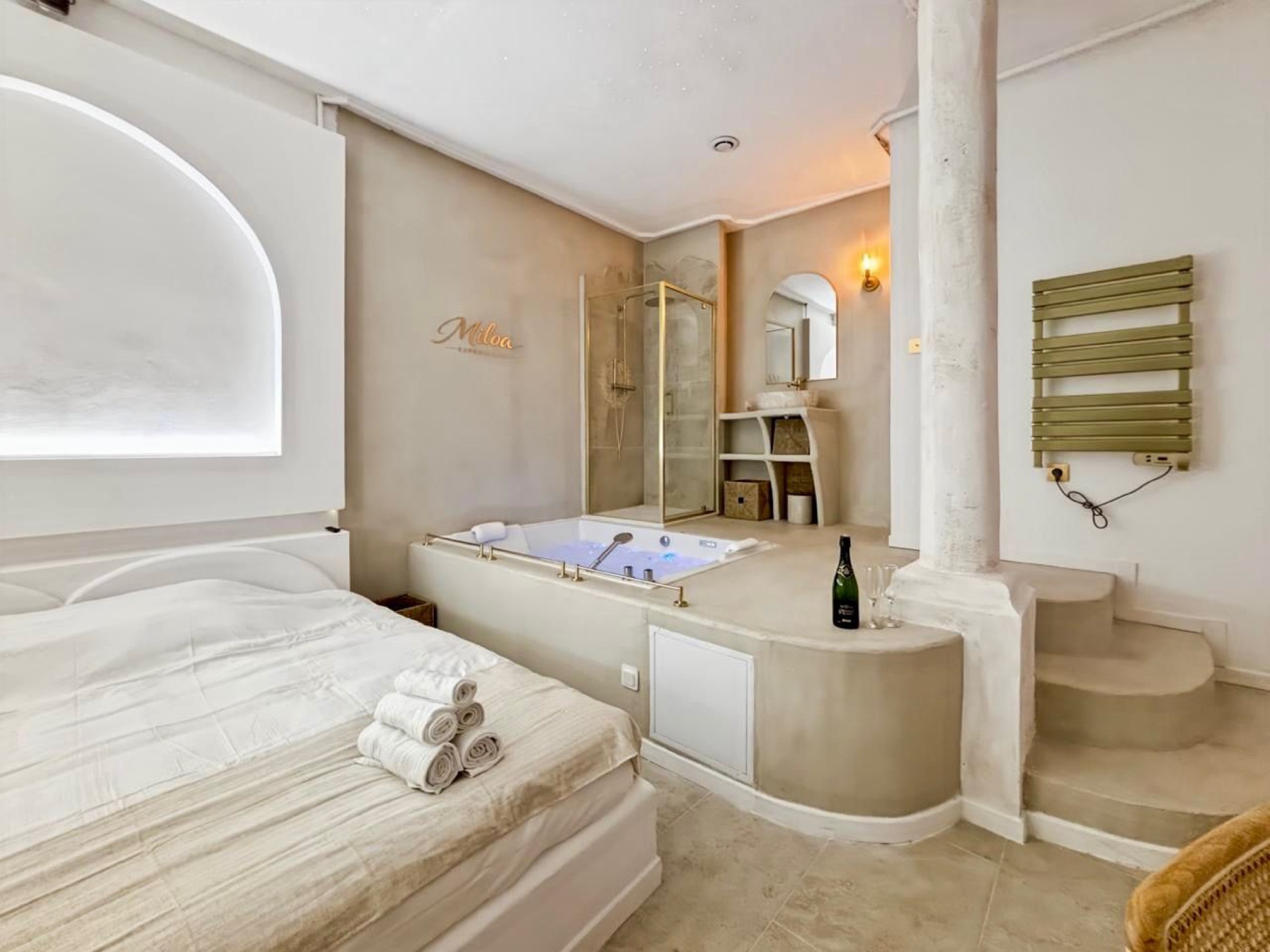 Bed and jacuzzi seen from the entrance of the Balnéo Room