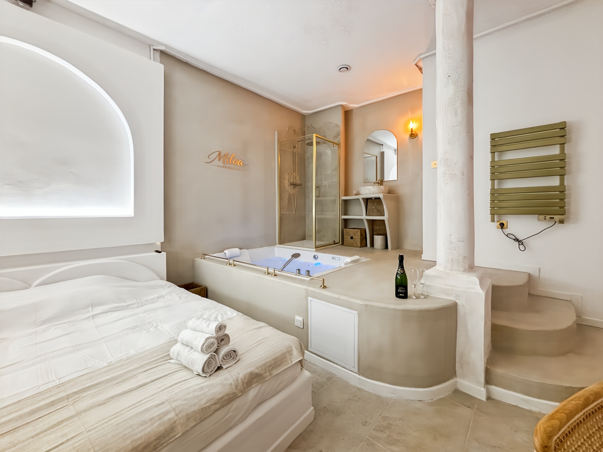 Cosy bed facing the jacuzzi and colonnade of the Balnéo Room