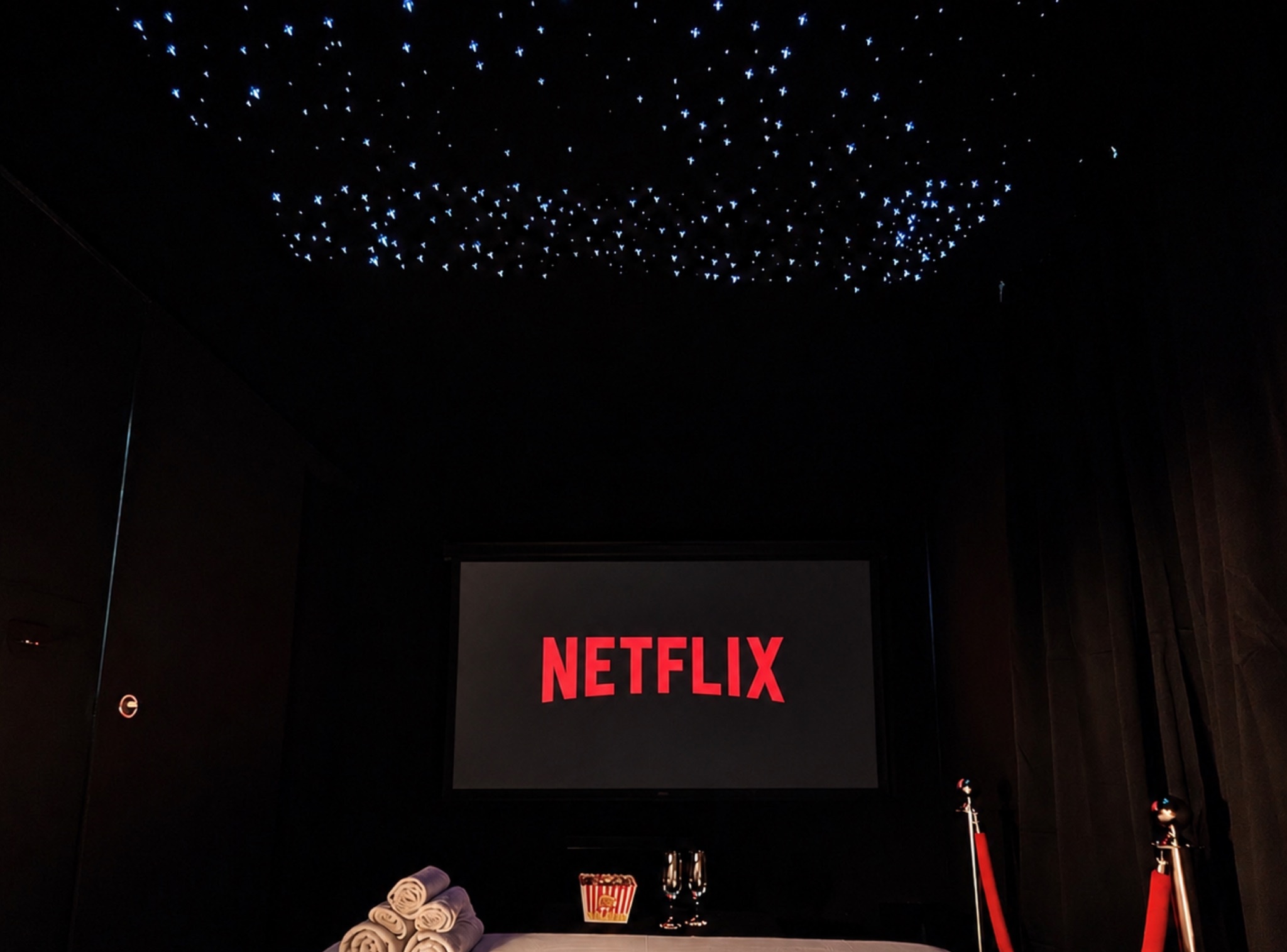 Ciné Room in Tarbes: private screening room with 4K screen, starlit ceiling and red ropes